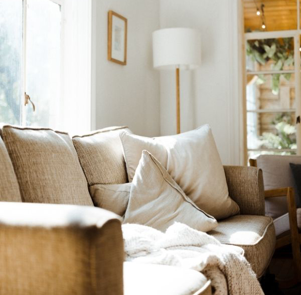 light grey couch with standing lamp and bright window light